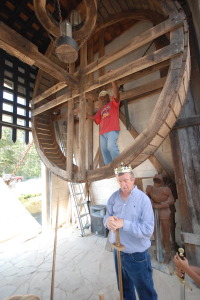 Newman discusses medieval life while a helper raises the drawbridge using a human windlass.