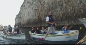 Boats carrying tourists from many different countries line up to enter the Blue Grotto.
