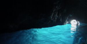 Inside the Blue Grotto, the eerie blue light illuminates the cavern while singing boatmen move tourists about.